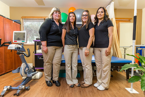 A group of healthcare professionals posing together in a therapy office.