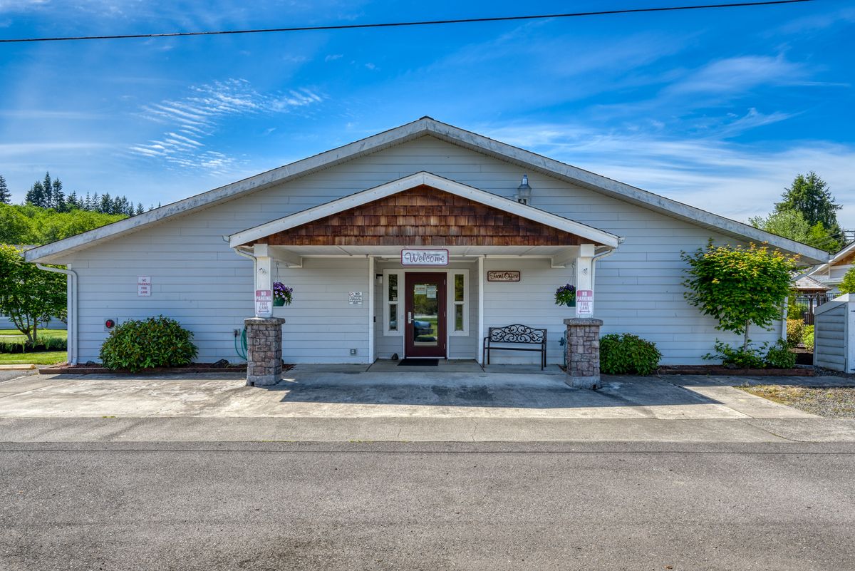 The exterior of a funeral home with white siding and a front entrance under a gabled roof.
