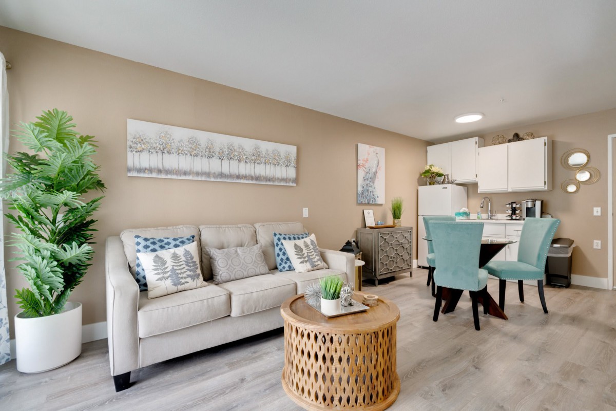 A modern living room with a neutral color scheme featuring a comfortable sofa, a woven coffee table, and stylish decor.