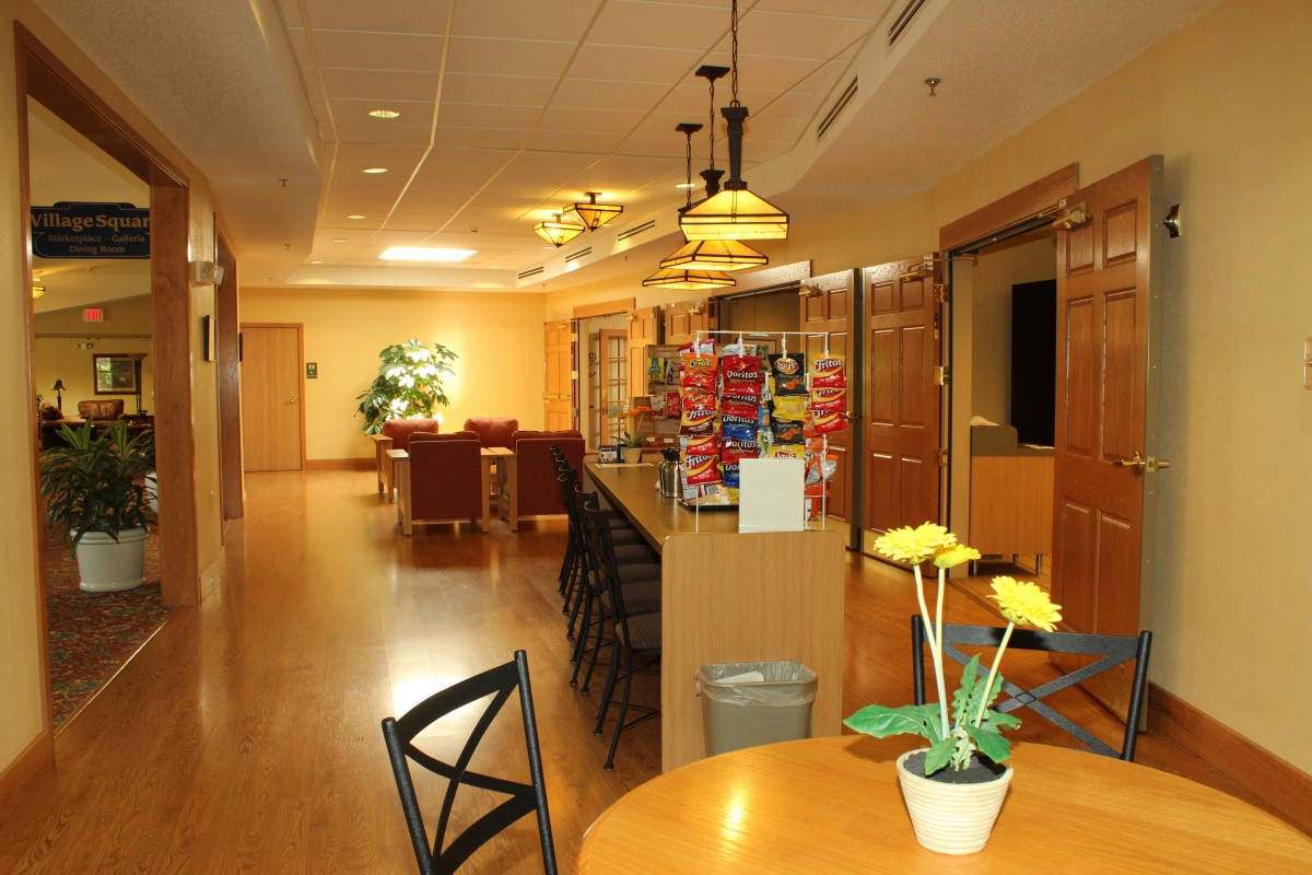 A warmly lit lobby area with seating, a reception desk, and decorative plants.