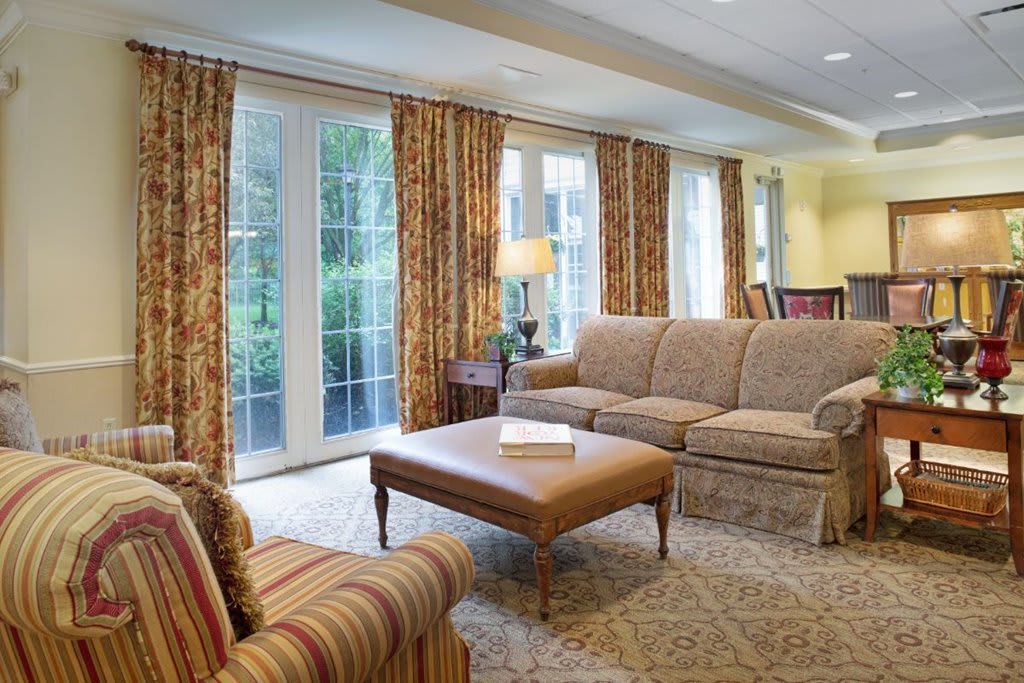 A cozy living room with patterned curtains, a comfortable sofa, and a center table.