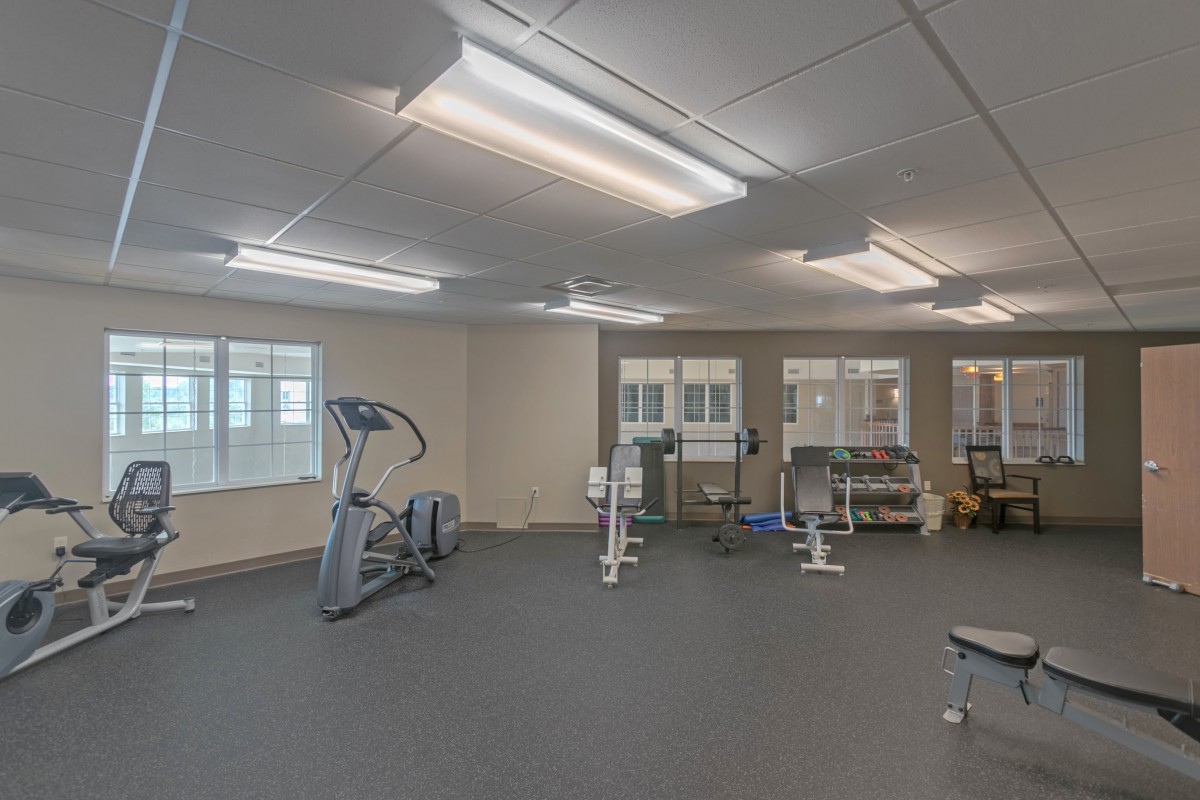 A spacious gym room equipped with various exercise machines and weights.