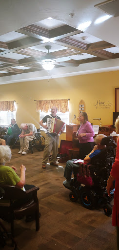 A lively performance with accordion music, bringing joy to the elderly residents in a community center.