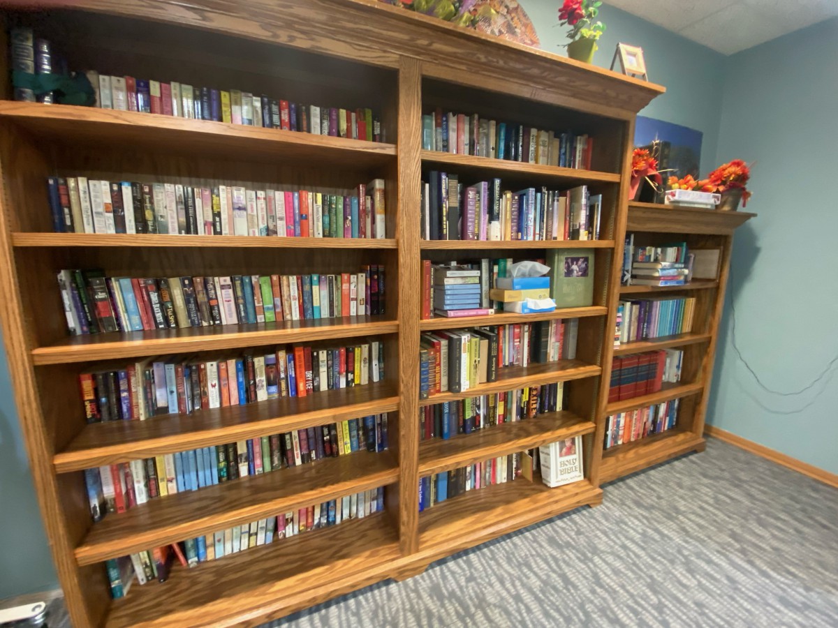 A cozy library with wooden bookshelves filled with a variety of books.