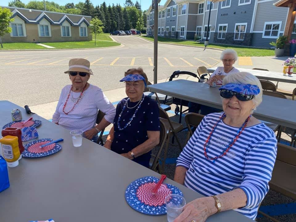 A group of seniors enjoying an outdoor social event at a picnic table.