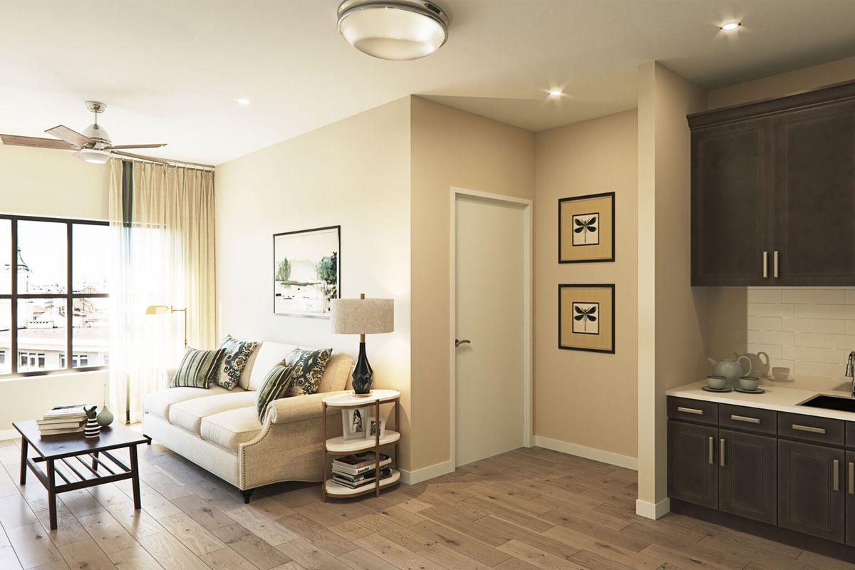 A modern living room featuring a comfortable sofa, stylish lamp, and framed artwork on the walls.