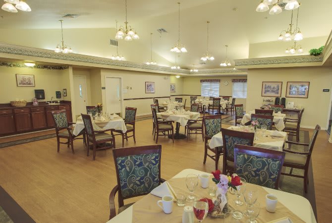 An indoor dining room with several set tables and chairs arranged neatly.