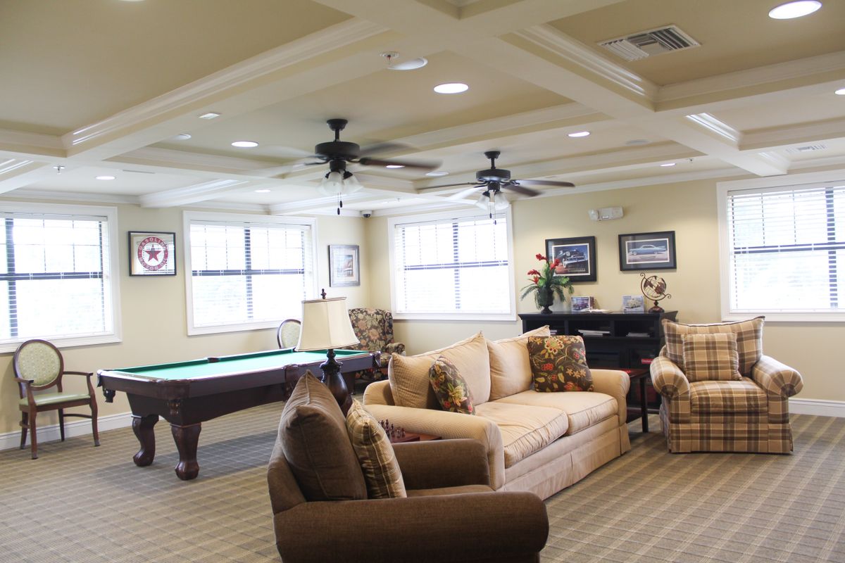 A spacious living room featuring a pool table and comfortable seating area.