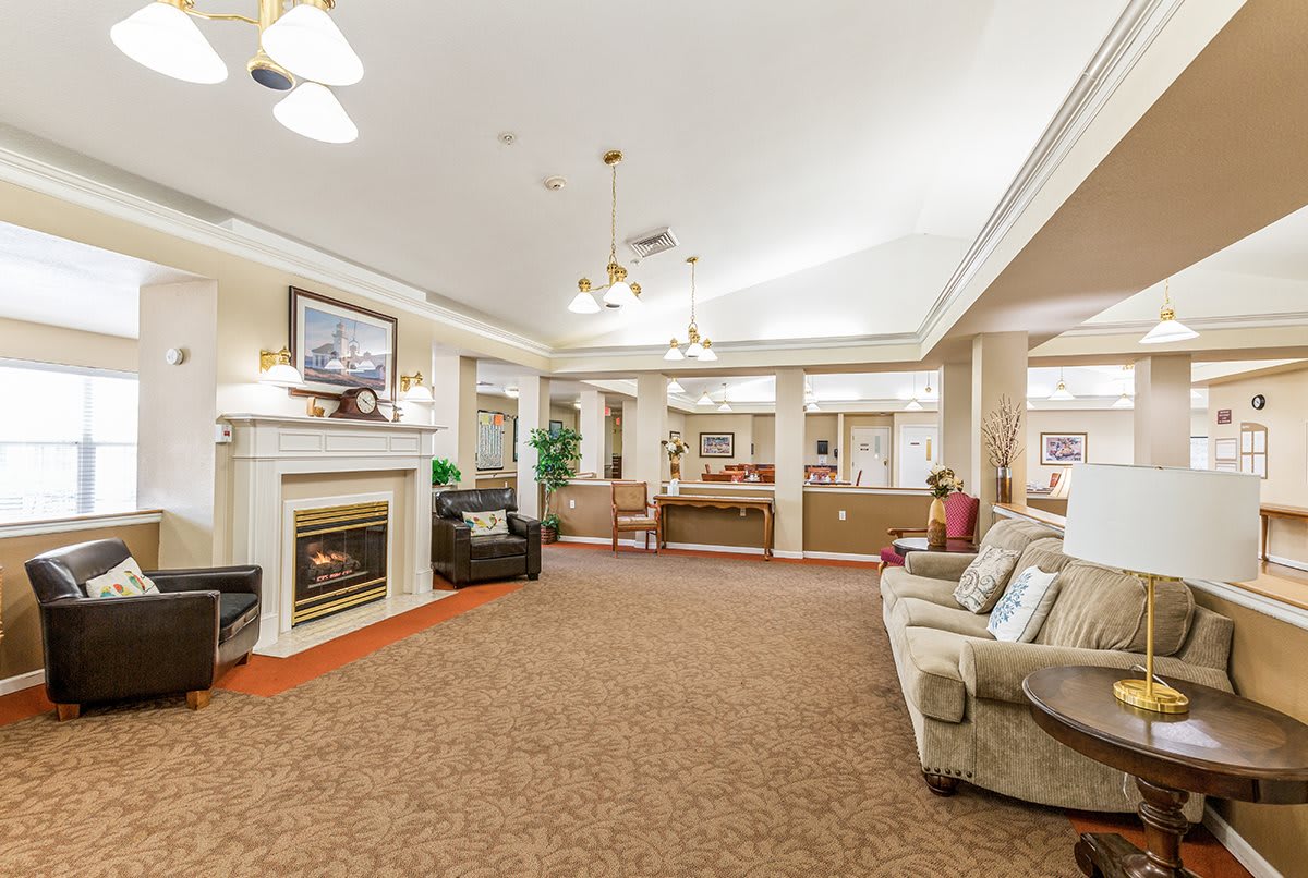 A spacious and elegantly decorated living room with a fireplace, comfortable sofas, and warm lighting.