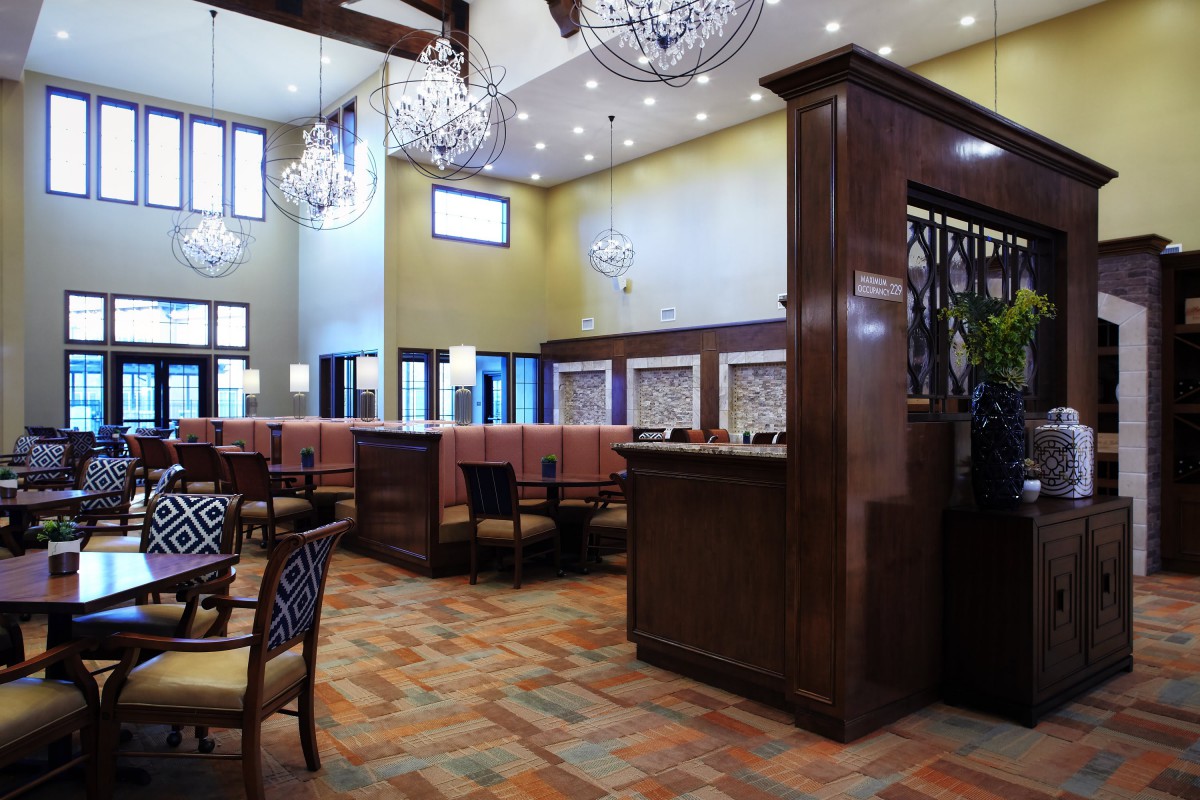 Elegant restaurant interior with chandeliers and upholstered seating.