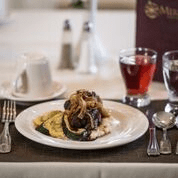 A gourmet meal elegantly served at a restaurant, accompanied by drinks.