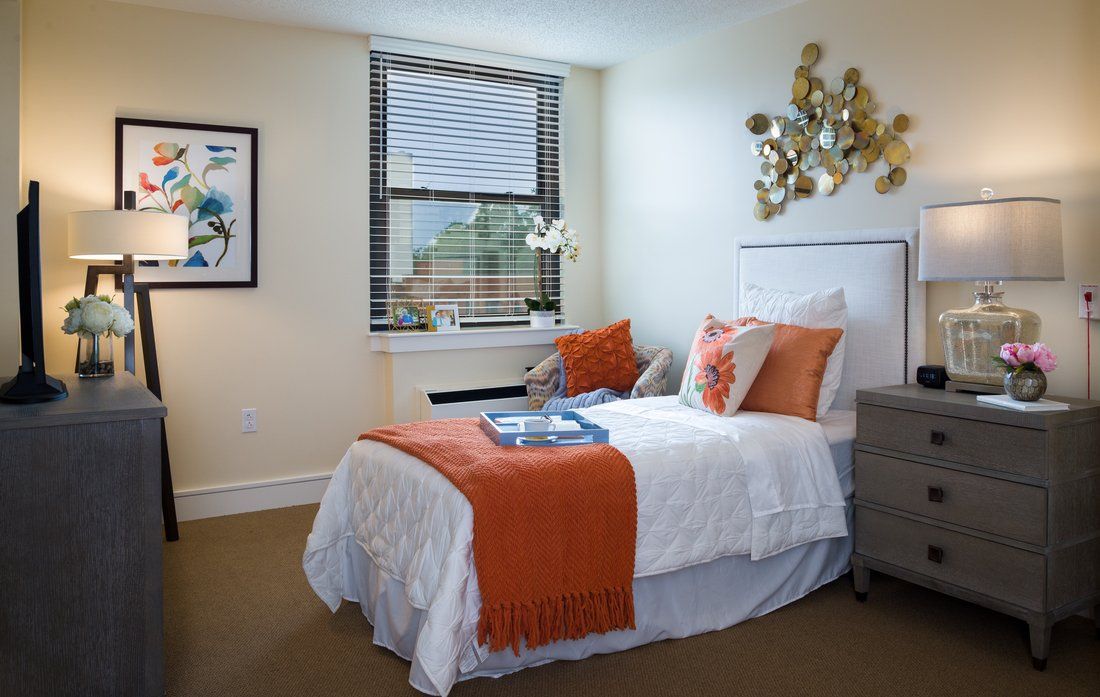 Modern bedroom with orange accents and stylish decor.