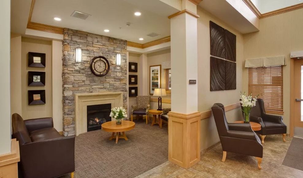 A cozy living room with a stone fireplace, modern furniture, and warm lighting.