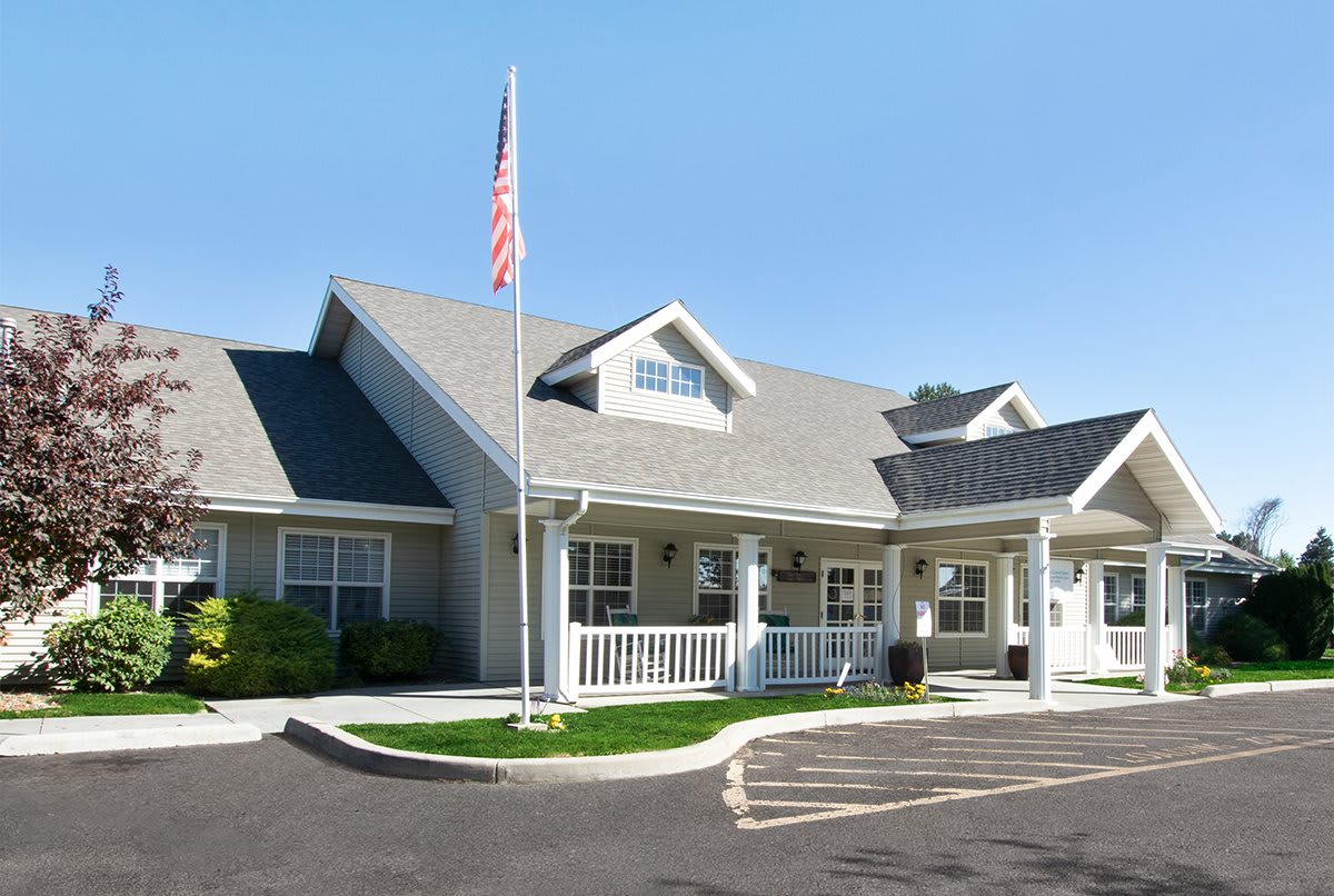 A residential building with a front porch and an American flag.
