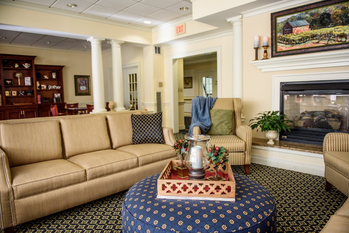 A cozy living room with a comfortable sofa, a patterned ottoman, and elegant home decor.