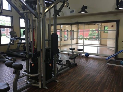 A well-equipped gym area featuring various exercise machines and weights.