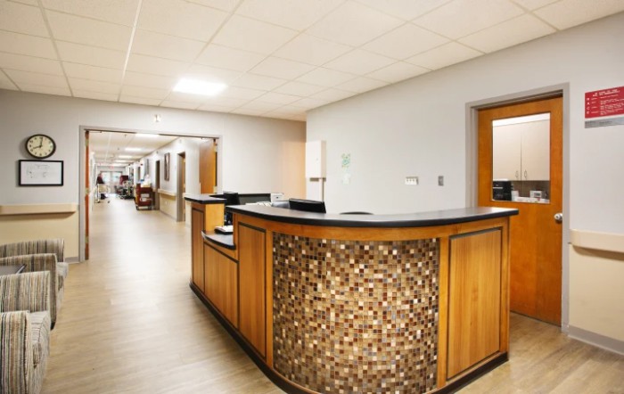 This image shows a hospital corridor with a reception desk and office doors.