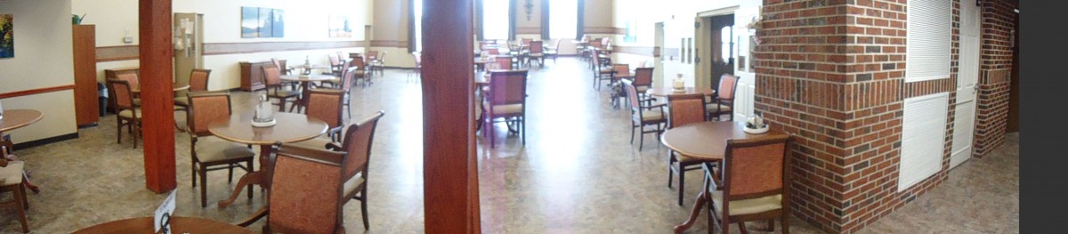 An empty dining room with neatly arranged chairs and tables in front of large windows.
