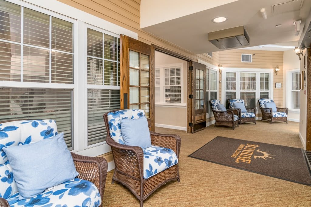 A cozy indoor lounge with wicker chairs and floral cushions, perfect for relaxation.