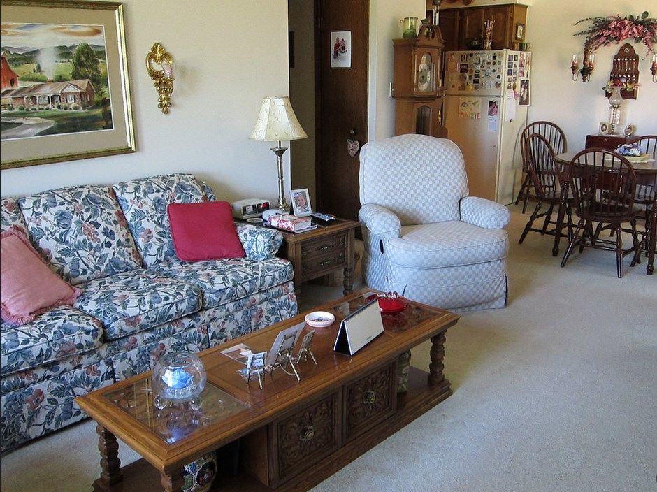 A cozy living room with a floral sofa, armchair, and wooden coffee table.
