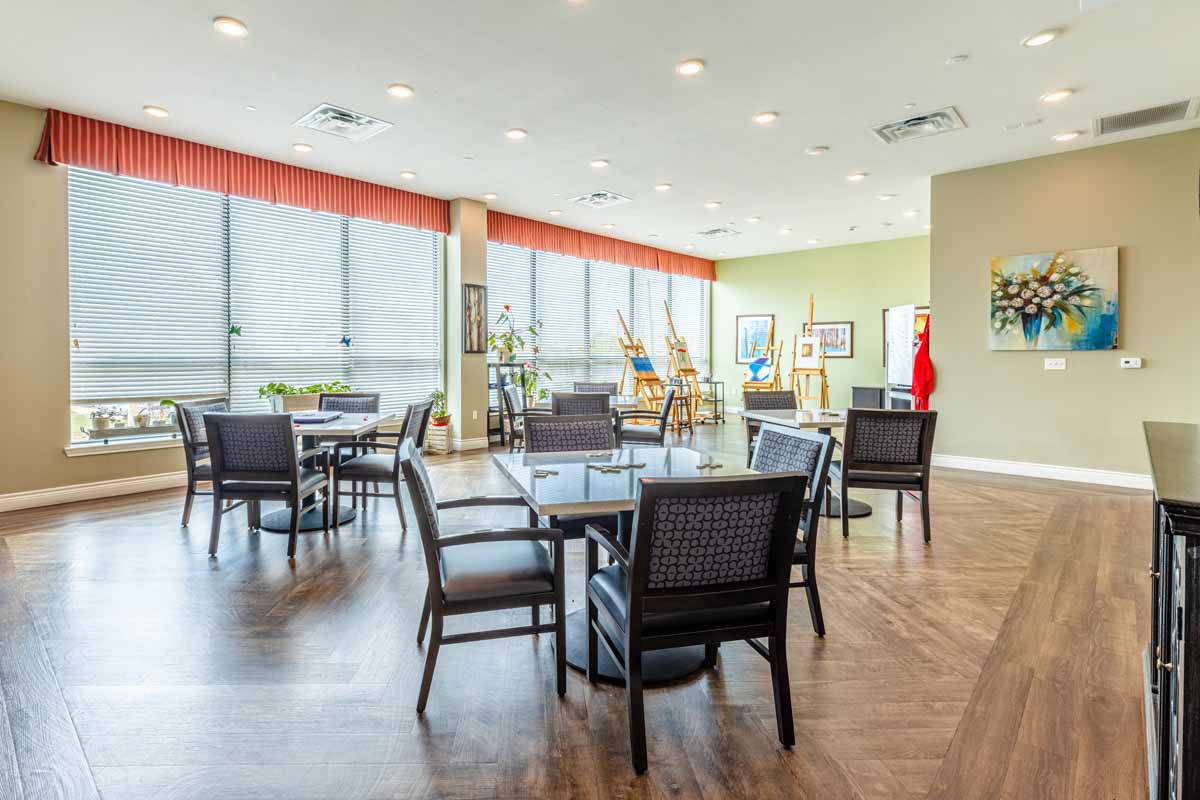 A modern dining area with wooden flooring and large windows.