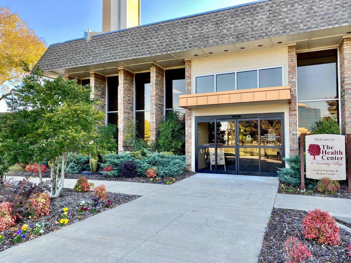 Entrance of a modern building with landscaped surroundings.