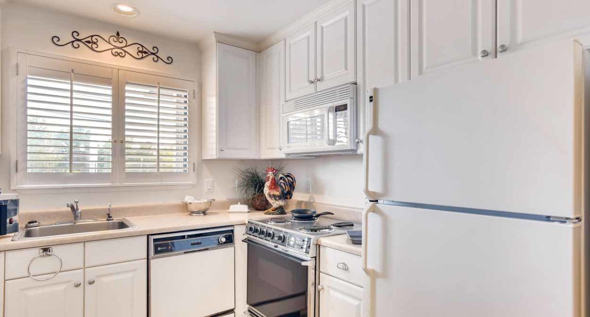 A bright kitchen with modern appliances and white cabinetry.