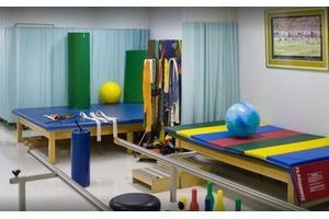 A well-equipped physical therapy room with exercise mats and therapy balls.