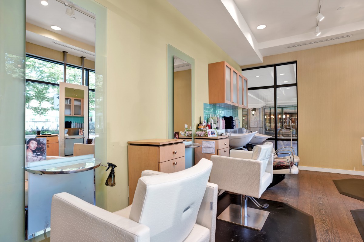 A modern salon interior with styling stations and chairs.