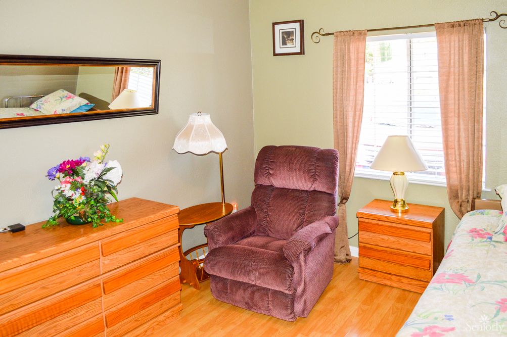 A cozy living room with a comfortable armchair and elegant wooden furniture.
