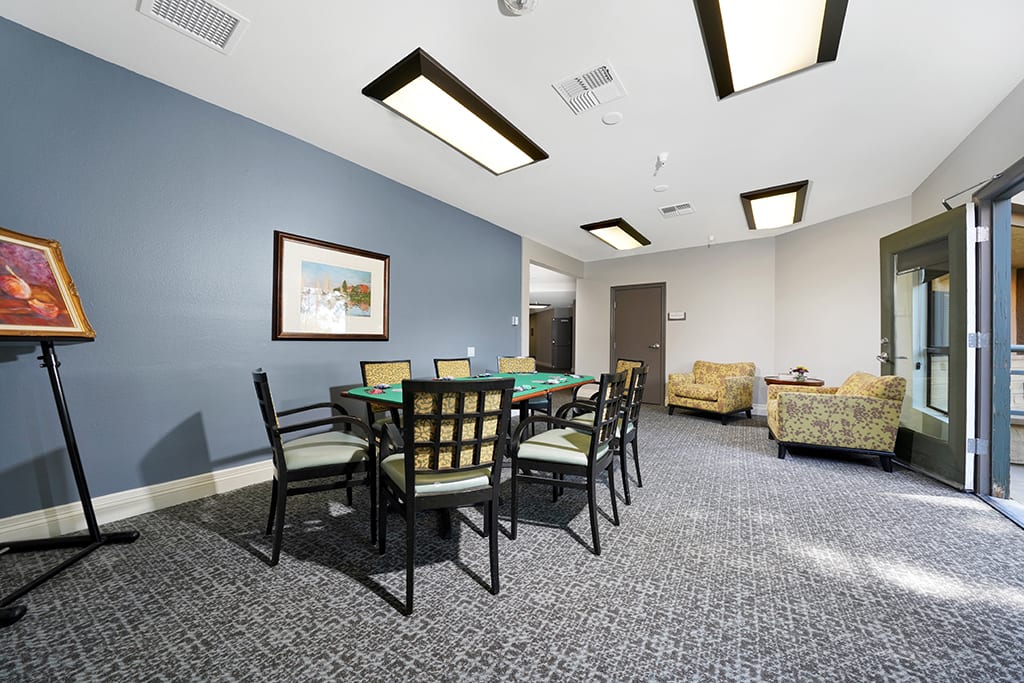 A well-lit meeting room with a large table, chairs, and comfortable seating.