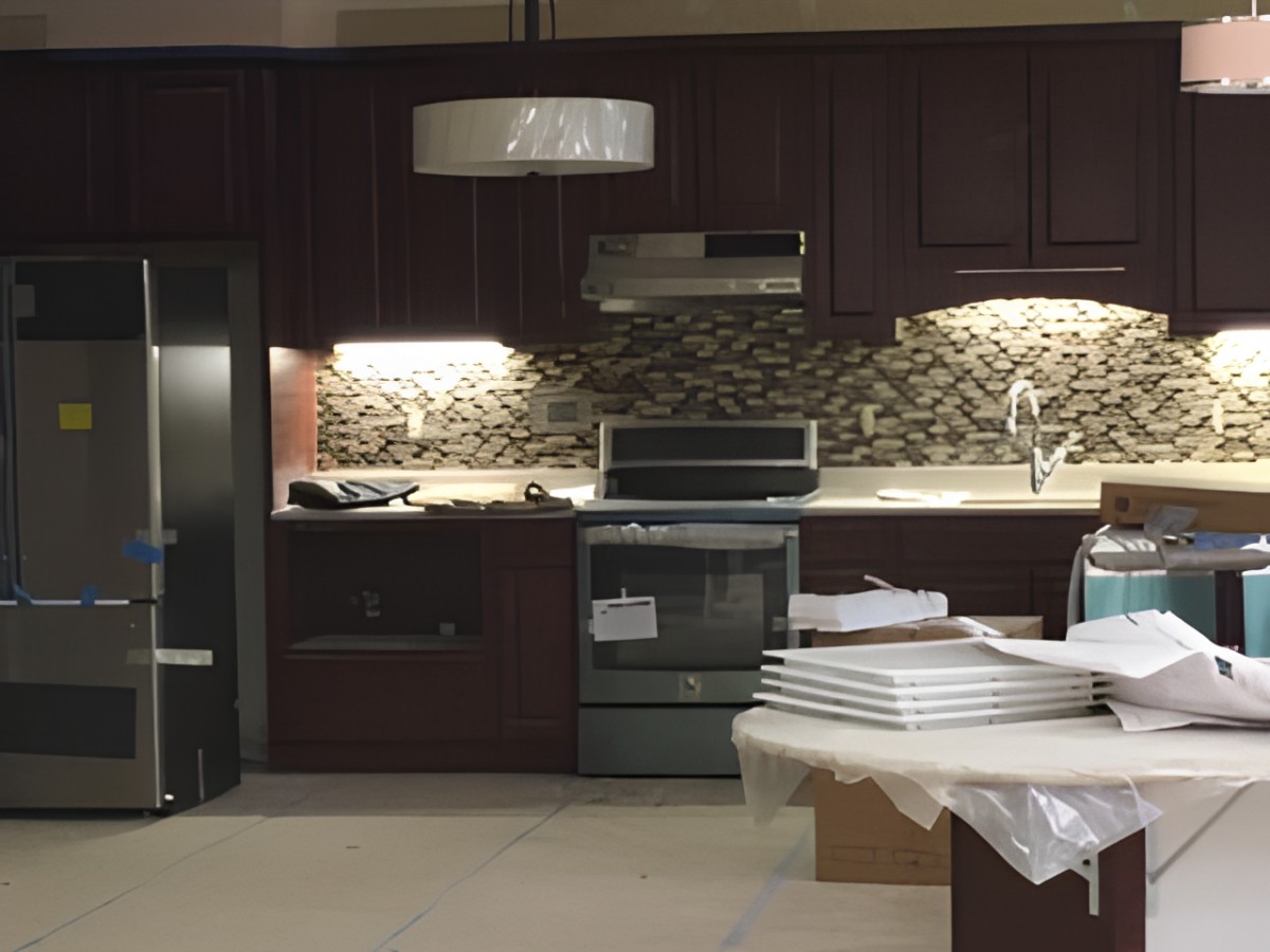 A modern kitchen with dark cabinetry, stainless steel appliances, and a stylish backsplash.