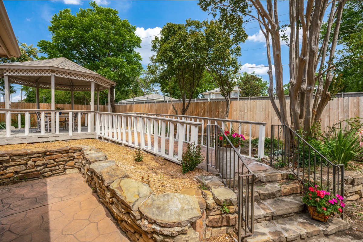 A picturesque backyard featuring a gazebo and landscaped stone pathways.