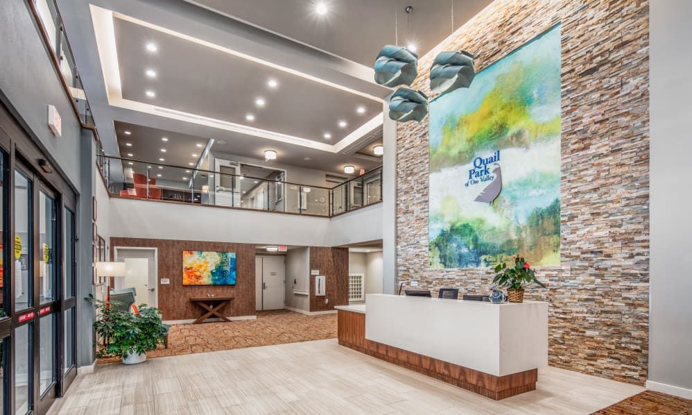 A modern lobby with sleek interior design, featuring a large piece of colorful artwork and contemporary lighting fixtures.