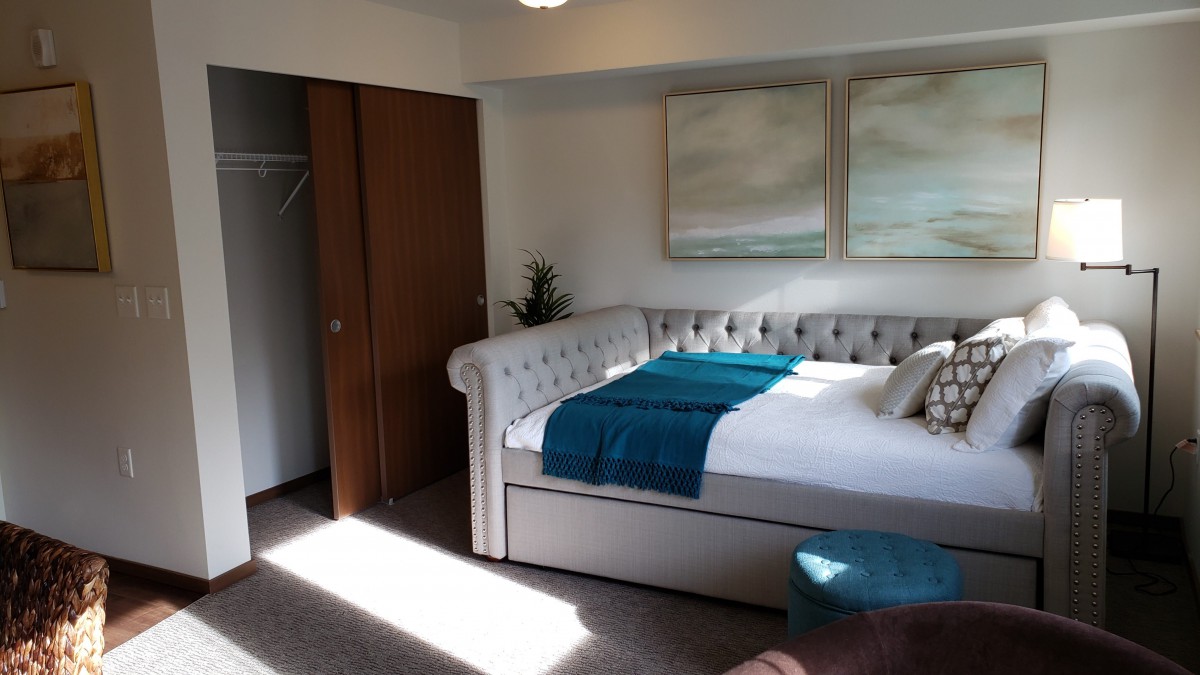 A cozy bedroom with a stylish bed and minimalist decor.