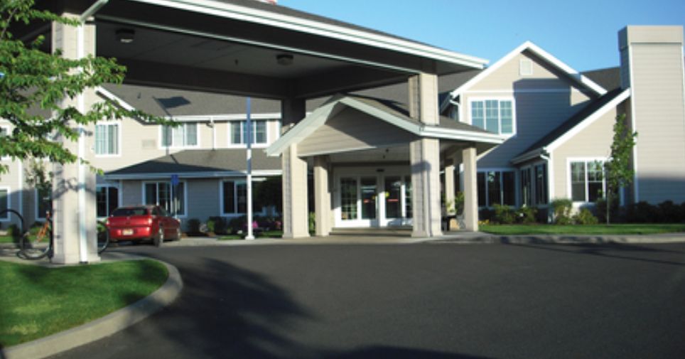Entrance of a building with a covered driveway and columns.