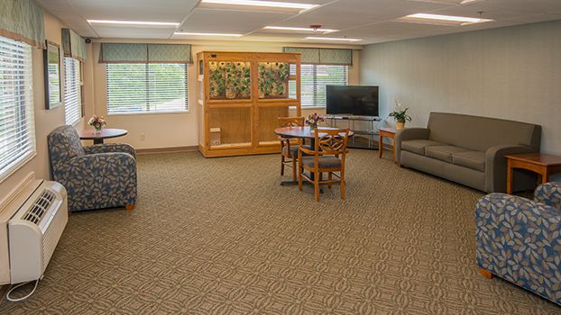 Spacious living room with comfortable seating, a television, and large windows.