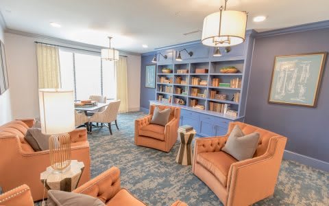 A cozy living room with colorful furniture and a well-organized bookshelf.