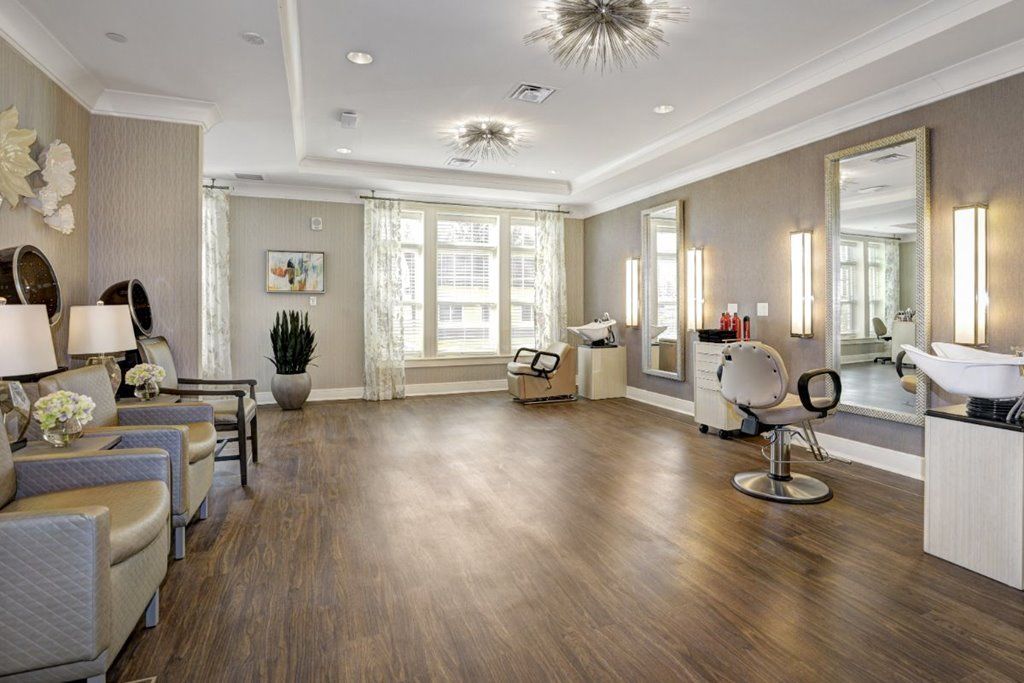 A modern salon interior featuring stylish chairs, mirrors, and elegant lighting.