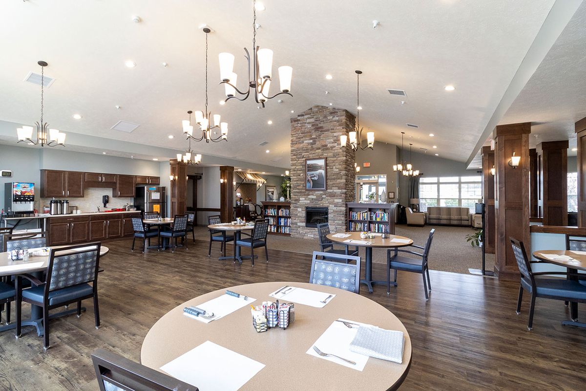 A spacious and modern dining area with elegant chandeliers and comfortable seating.