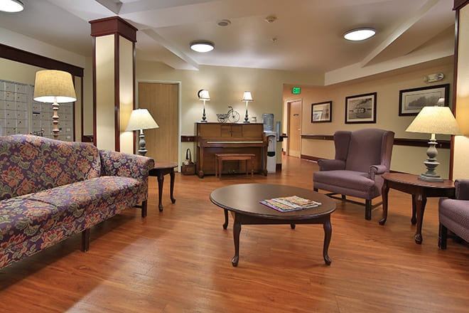 A warmly decorated lobby area with comfortable seating and a piano.