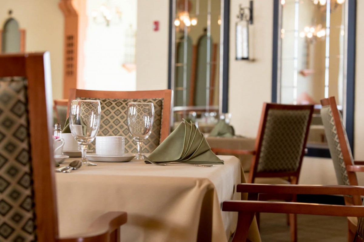An elegantly set table in a restaurant, featuring neatly arranged glasses and folded napkins.