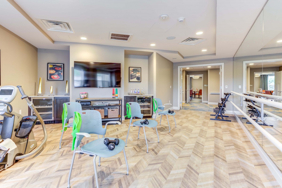 A modern interior space with a seating area, equipped with a television and brightly lit ambiance.