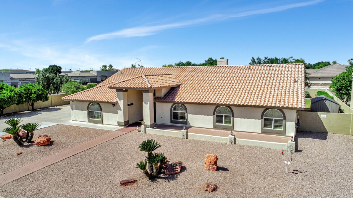 A single-story house with a tile roof in a desert landscape.