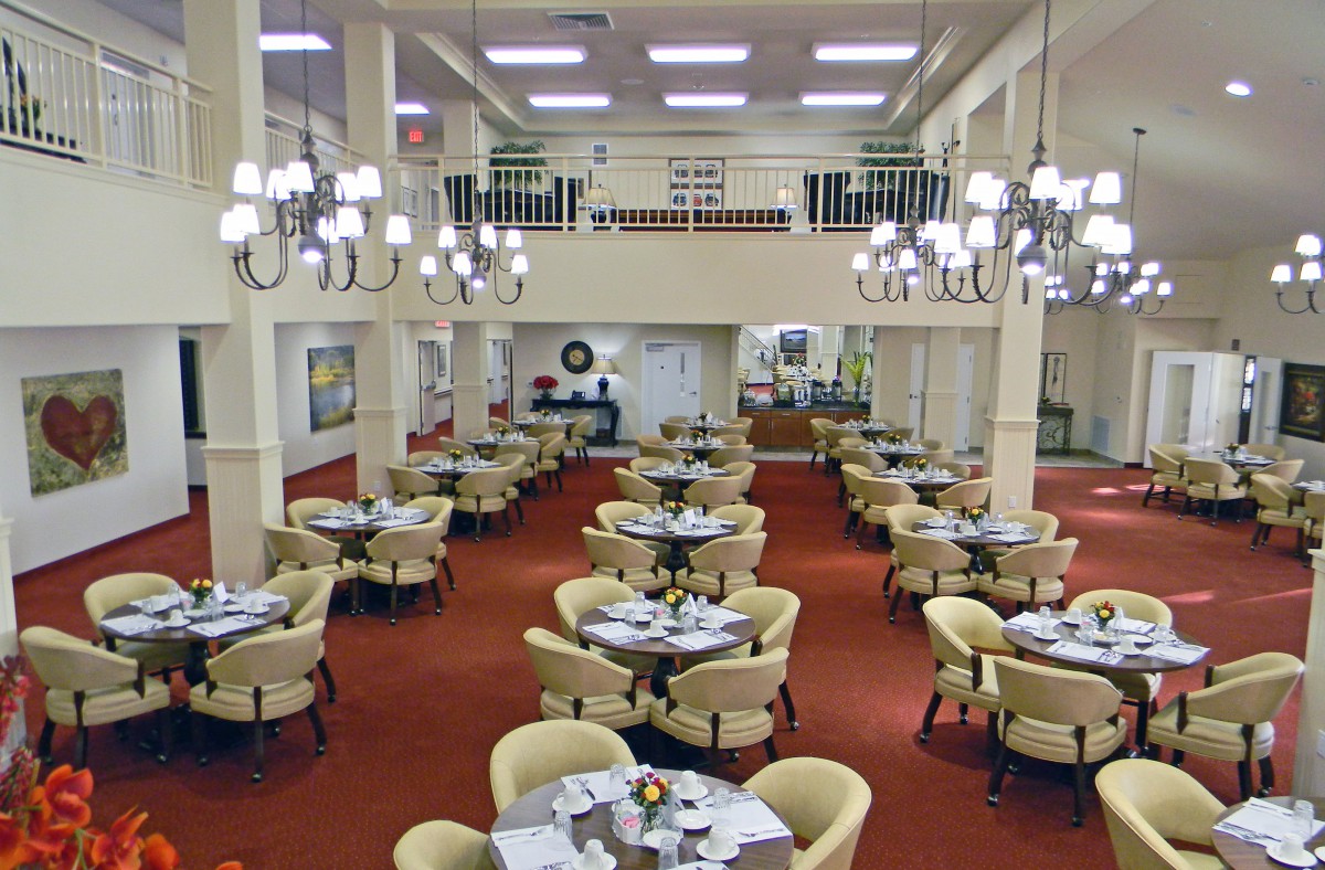 Spacious dining area with elegant chandeliers and neatly arranged tables and chairs.