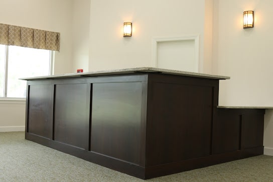 A modern wooden reception counter in a spacious interior.