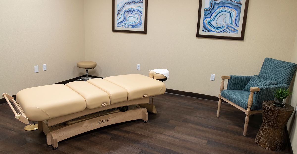 A chiropractic treatment room featuring a treatment table and minimalist decor.