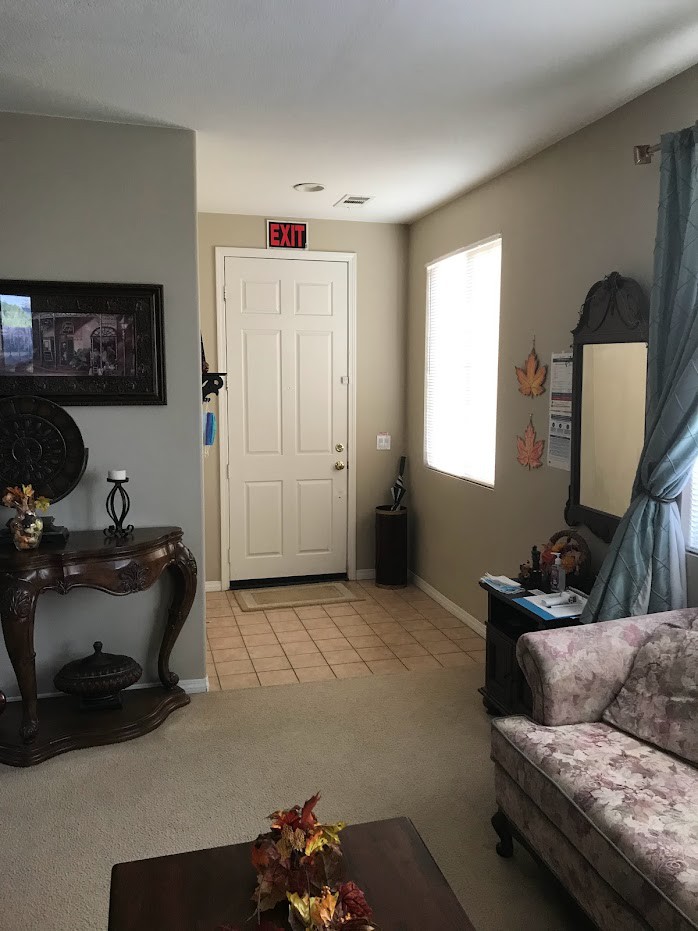 A cozy living room with a view of the front door, featuring stylish furniture and decor.