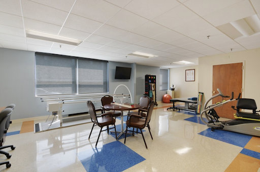 A spacious rehabilitation room equipped with exercise tools and a comfortable seating area.