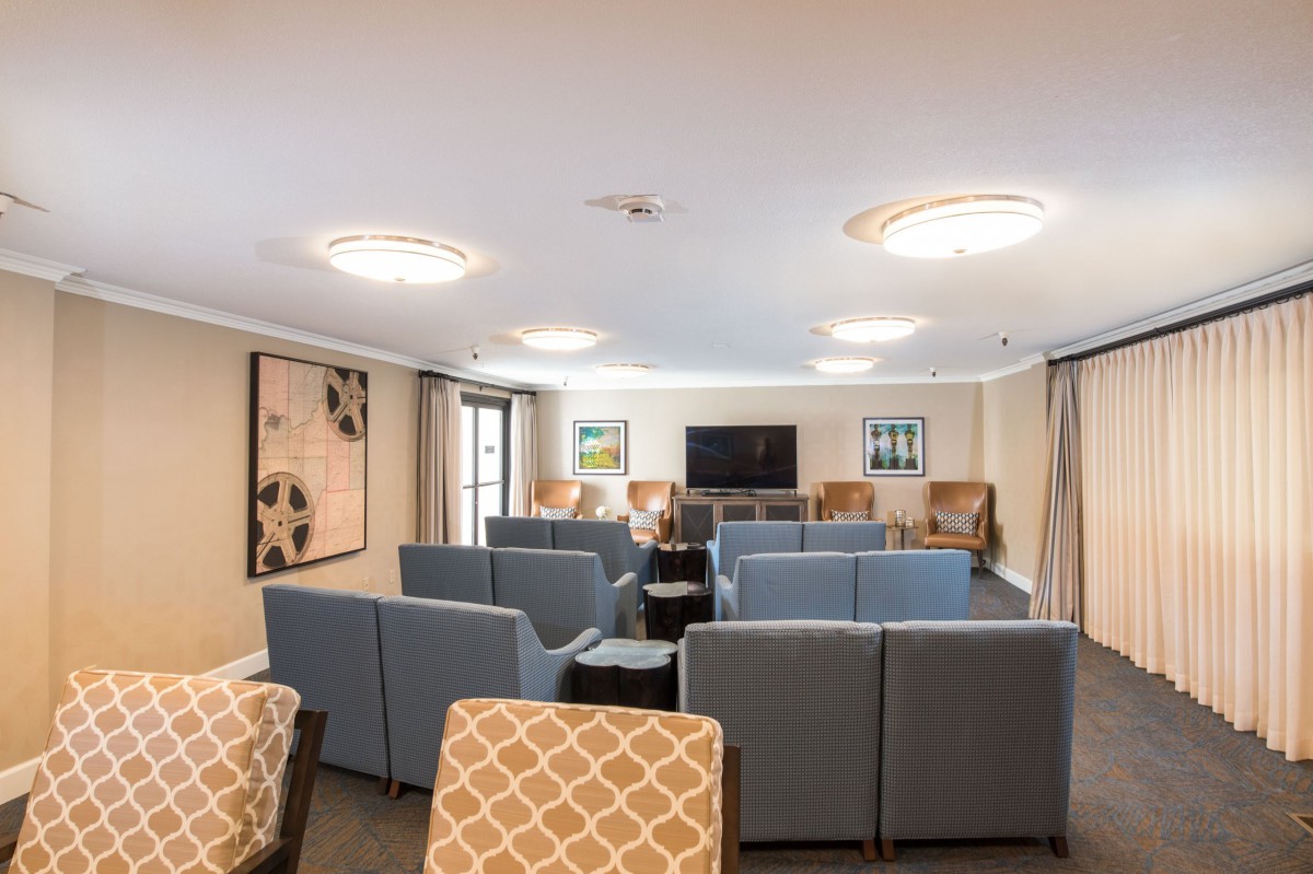 A comfortable lounge area with multiple seating arrangements and a large television, ideal for meetings or relaxation.